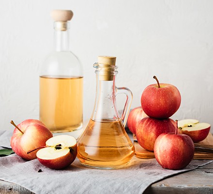Bottle of apple cider vinegar with apples