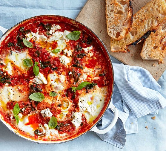 Baked eggs with spinach, tomatoes, ricotta and basil Baked eggs in a casserole dish with spinach, tomatoes, ricotta & basil