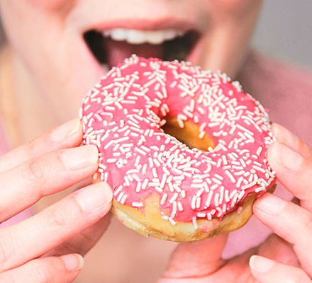 Someone about to eat a doughnut