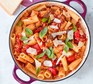 Caponata pasta in pan, garnished with basil and parmesan