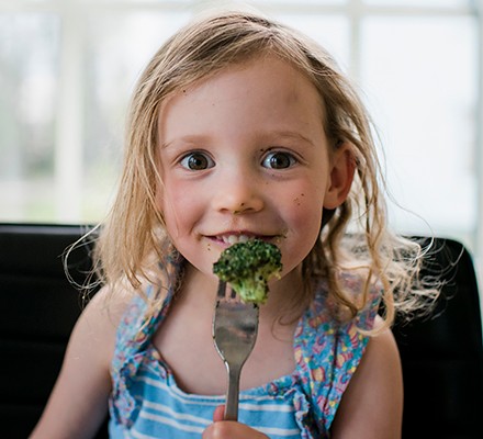 Child eating broccoli