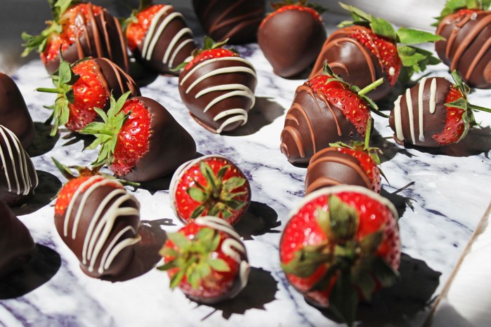 Chocolate-dipped strawberries Chocolate-coated strawberries on a stone surface
