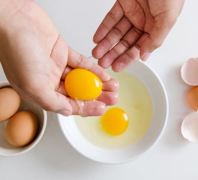 Top 10 ways with leftover egg whites and yolks Separating egg yolks and whites into a bowl with hands