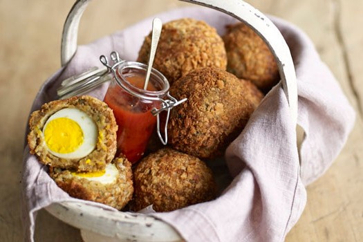 Falafel scotch eggs Homemade scotch eggs in a blanket with a pot of sauce