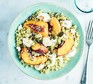 Feta & peach couscous A plate with feta & peach couscous and a fork alongside