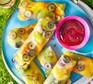 Fruit rice paper rolls with coulis dip Fruit rice paper rolls on a blue plate with coulis dip