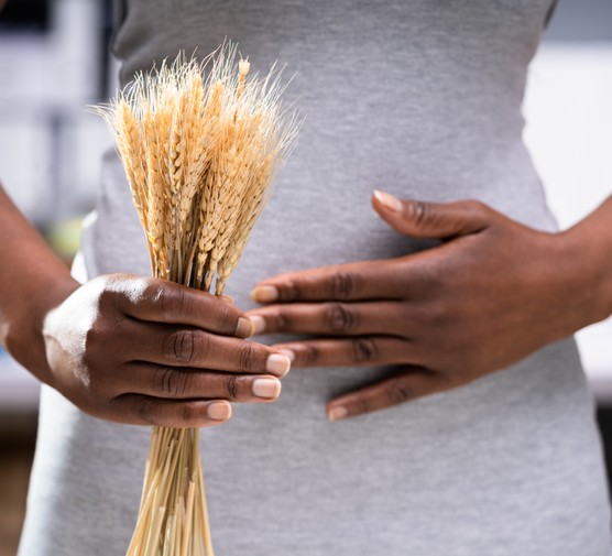 Coeliac disease And gluten intolerance. Women holding spikelet of wheat
