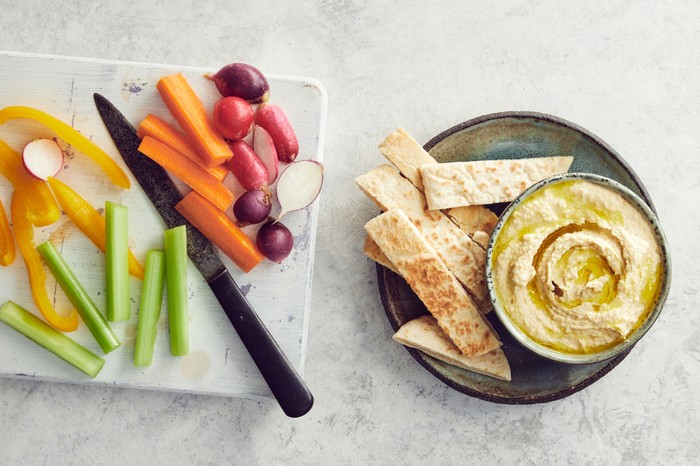Hummus Pot of hummus with crackers and vegetable batons