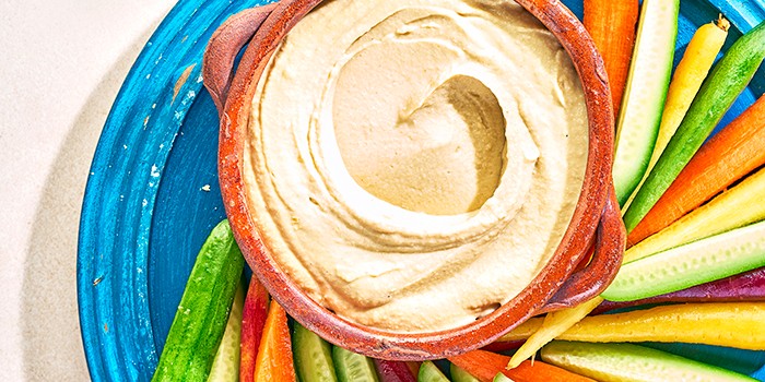 A pot of hummus with vegetable crudites