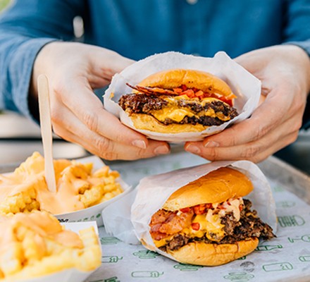 Man eating cheeseburger and chips