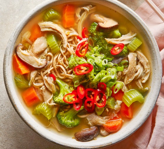 A bowl of miso chicken noodle soup, garnished with sliced red chilli