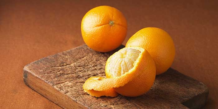 Three oranges on a chopping board