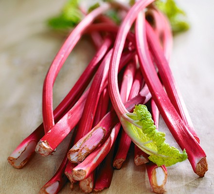 Stems of brightly coloured rhubarb lying on a worktop