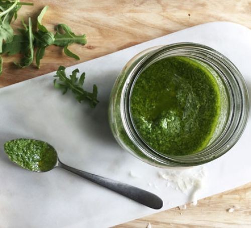Rocket pesto in a jar with a spoon