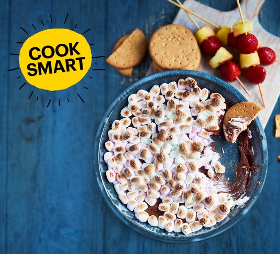 S'mores dip S'mores dip in a bowl with biscuits and fruit skewers next to it