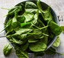 Spinach in pot on white table