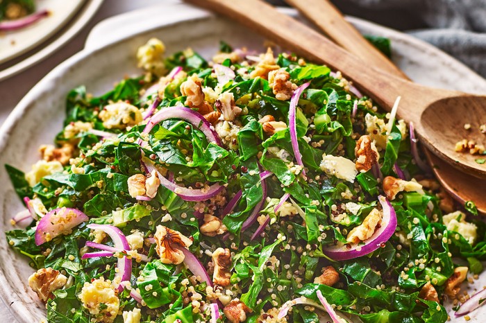 Spring green salad with parsley & blue cheese A bowl on green salad with salad servers