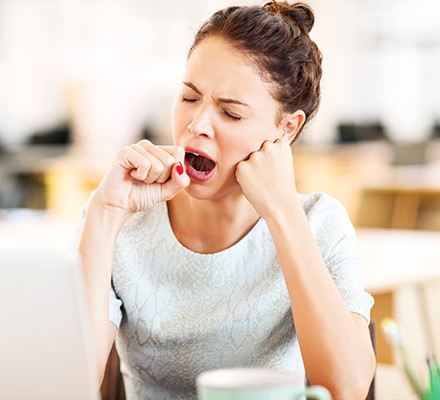 Woman yawning at desk after lunch