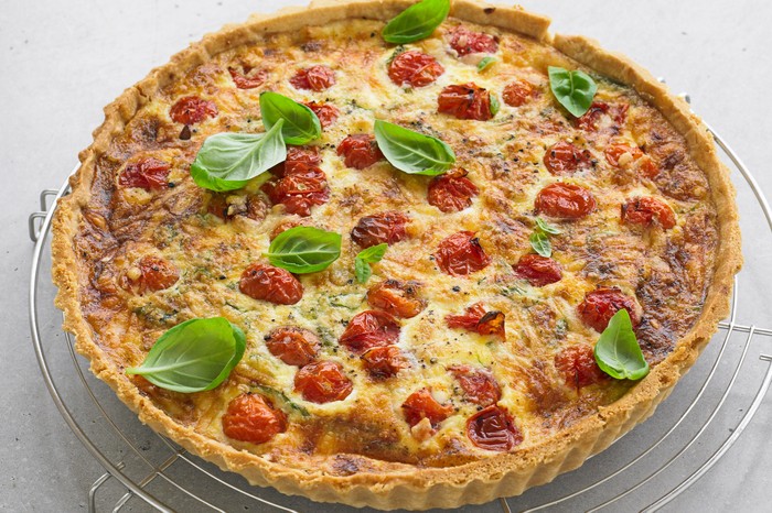 Roasted tomato, basil & Parmesan quiche Whole quiche topped with tomatoes and basil