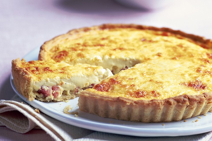 Ultimate quiche lorraine A quiche lorraine on a plate with one slice cut out of it