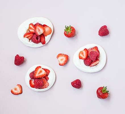 Three vegan meringues garnished with strawberries