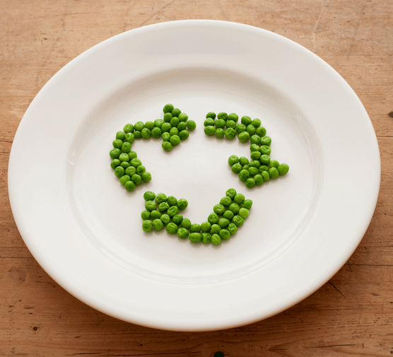 Peas on a plate in the shape of a recycling symbol